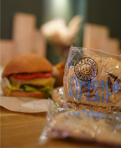 Cookies en gros plan avec un burger flou en arrière-plan, photo par l'agence de communication Glick