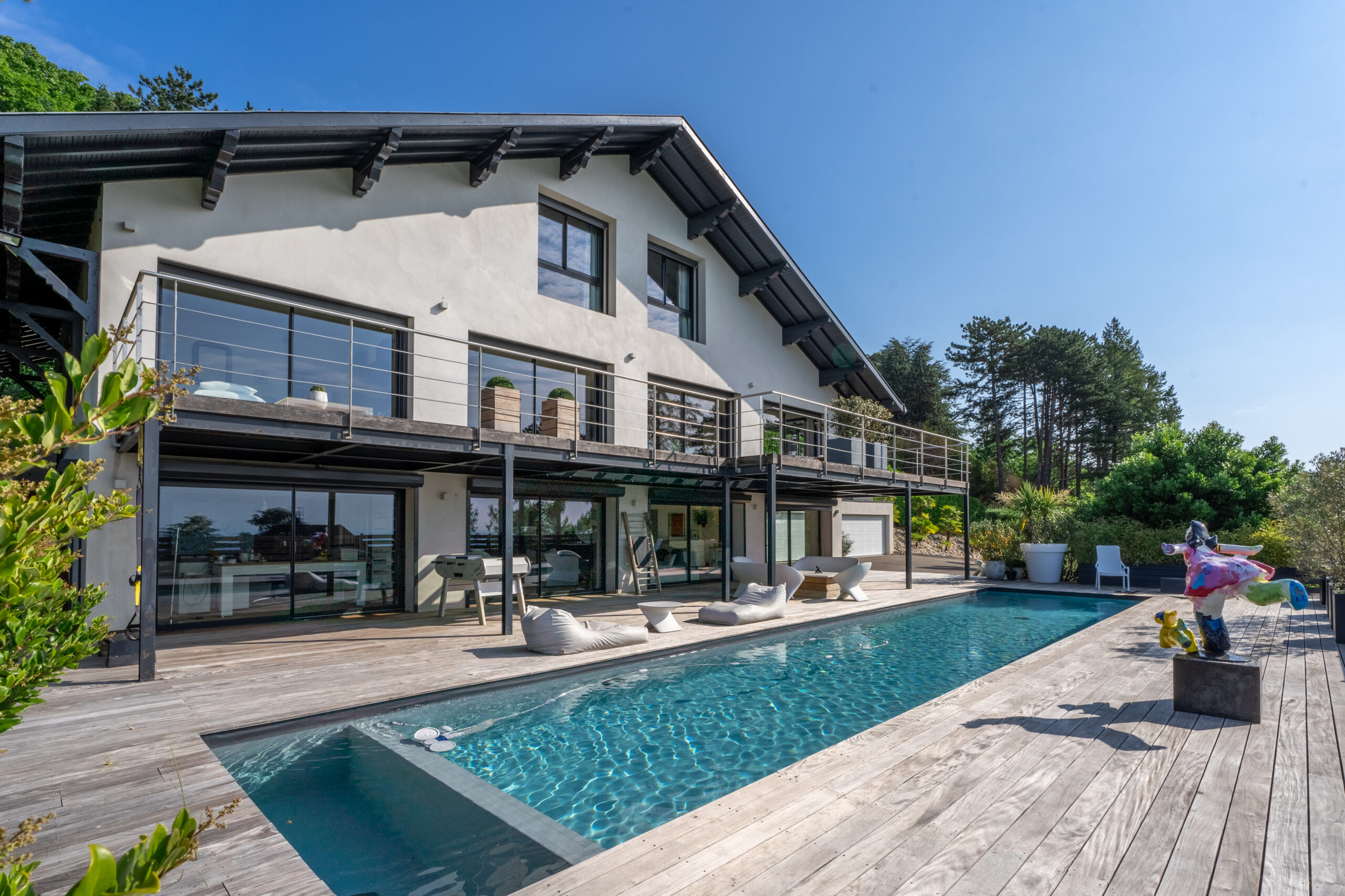 Maison luxueuse et de prestige avec piscine vue de l'extérieur, photographiée par l'agence Glick à Mulhouse.